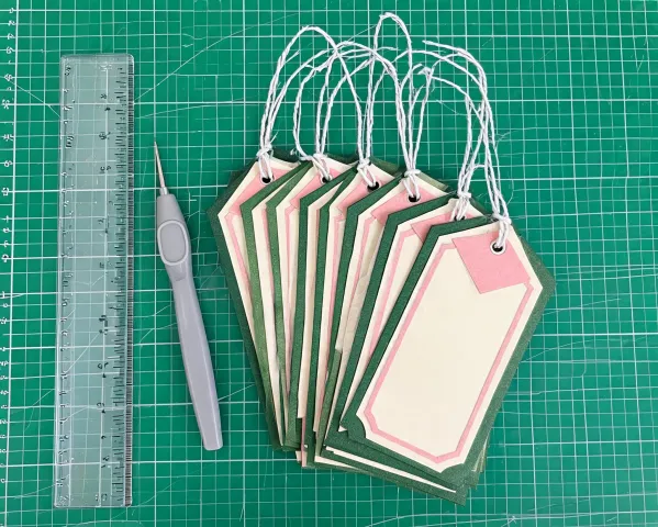 Cardstock gift tags on a cutting mat